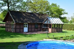 Ein zweistöckiges Haus mit Schwimmbad davor.