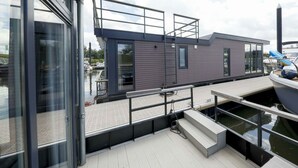 A modern boat with a deck, a small cabin, and a dock. - Holiday Home in Olburgen With Terrace (Olburgen)