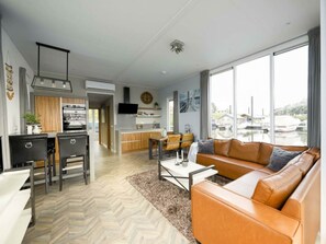 Ein modernes Wohnzimmer mit Sofa, Essbereich und Küche.