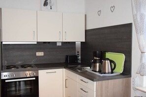 Eine Küche mit Herd, Backofen und Kaffeemaschine.