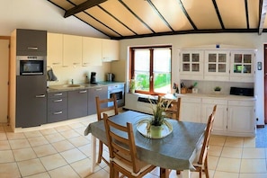 Una cocina con una mesa de comedor, sillas y un ventanal con vistas.
