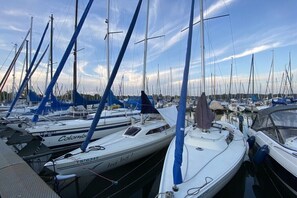 Ein Yachthafen mit mehreren Segelbooten, die festgemacht sind, mit Masten und Segeln.