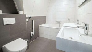 Un baño moderno con inodoro, bañera y lavamanos.