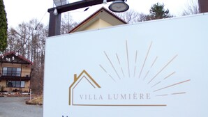 Un letrero de Villa Lumière con el logotipo de la casa y texto en japonés.