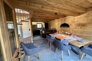 Ein Holzinterieur mit Essbereich, grauem Stuhl und einer hängenden Leuchte.