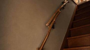 A wooden staircase with a handrail and a wall-mounted light fixture.