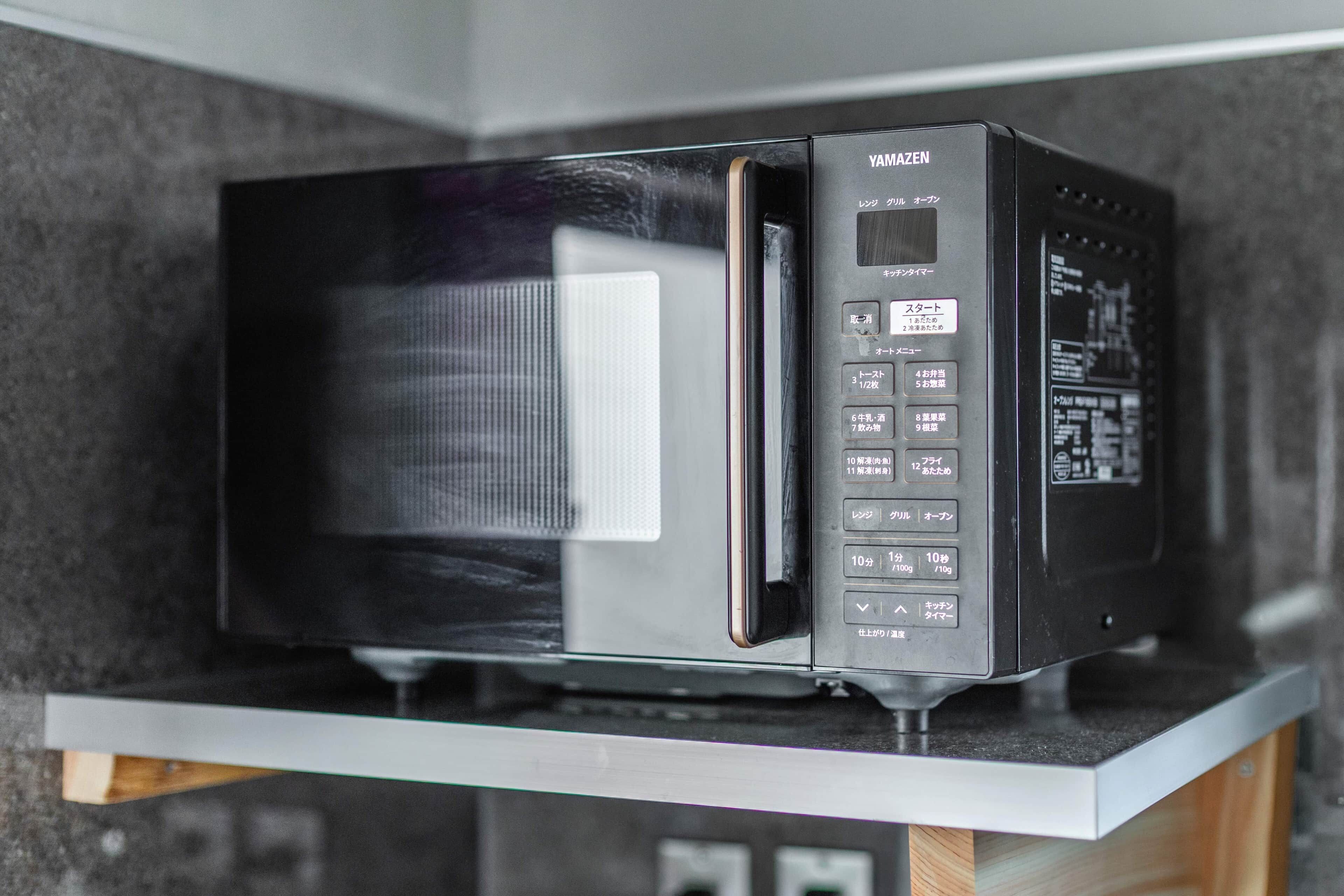 A black microwave oven on a kitchen counter.