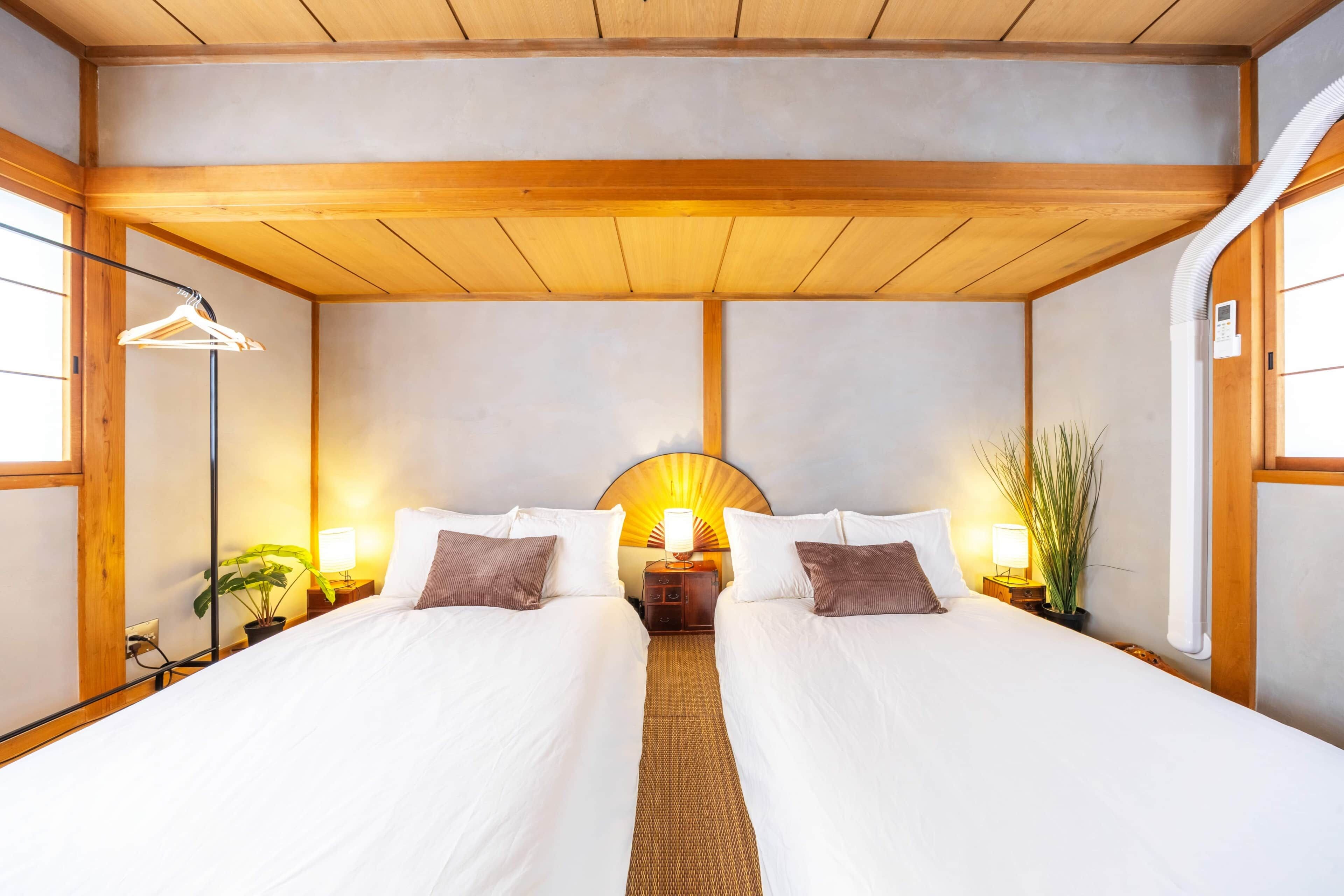 A double bed with a wooden headboard, bedside tables with lamps, and a wall-mounted fan.