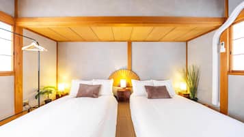 A double bed with a wooden headboard, bedside tables with lamps, and a wall-mounted fan.