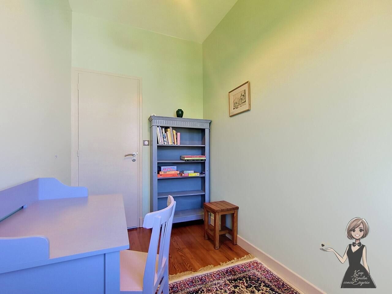 Een kamer met een witte deur, een blauwe boekenkast, een klein houten krukje en een stoel.