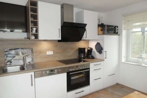 Eine moderne Küche mit Einbauofen, Mikrowelle und Kaffeemaschine.
