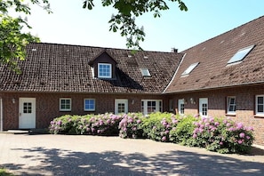 Ein Backsteinhaus mit einem Ziegeldach, einem kleinen Fenster und einer Tür.