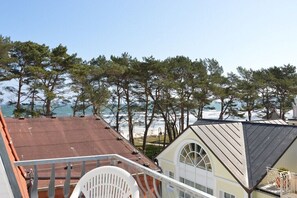 Ein Küstengebäude mit einem Balkon mit Blick auf Strand und Meer.