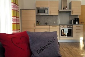 Eine moderne Küche mit Mikrowelle, Backofen und Kaffeemaschine.
