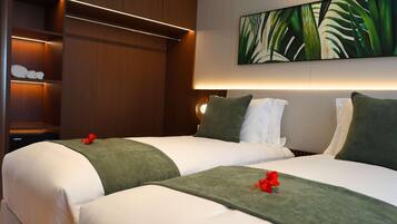 A hotel room with two beds, a large painting, and a wooden wardrobe with illuminated shelves.