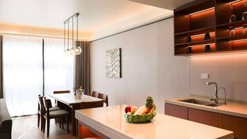 A modern kitchen with a central island, bar stools, and a dining area with chairs.