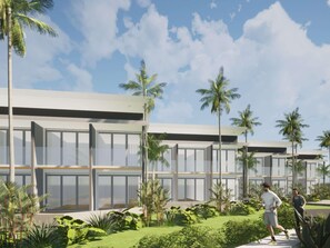 Un edificio moderno con amplios ventanales y un jardín cuidado con palmeras.