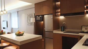 Une cuisine moderne dotée d’un îlot central, d’appareils électroménagers en acier inoxydable et de meubles de rangement en bois.