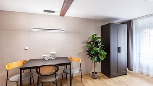 A dining area with a table, chairs, a potted plant, and a wardrobe. - Apartment "Harmonie Oasis" with Wi-Fi and Air Conditioning (Alsleben)