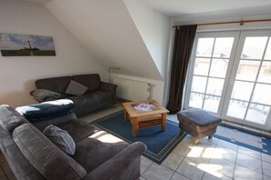 Ein Wohnzimmer mit einer Couch, einem Holztisch und einer Heizung.