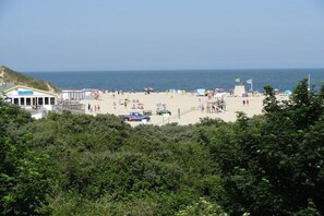 Ein Strand mit einem Gebäude, einem Steg und einer Flagge.