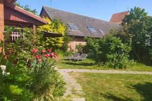 A house with a garden, a pathway, and two sun loungers. - Holiday home in KARBY with swimming pool (KARBY)