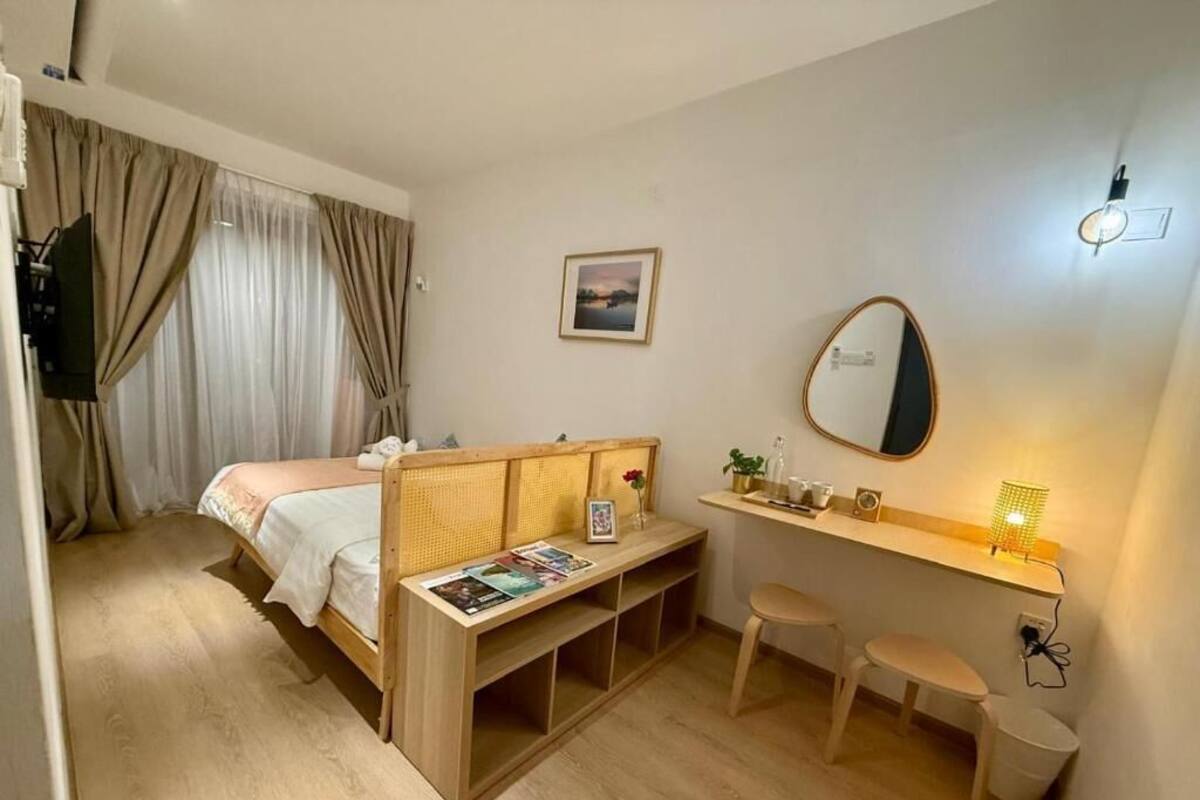 Ein Schlafzimmer mit Bett, Schreibtisch, Stuhl, Spiegel und Wandregal.