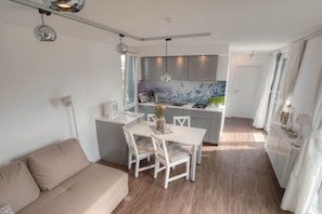 A compact living space with a kitchenette, dining area, and a sofa.