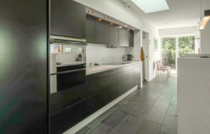 A modern kitchen with a black and white color scheme, a built-in oven, and a skylight. - Luxurious home in Ebeltoft with WiFi (Ebeltoft)