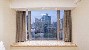 Una habitación con un ventanal amplio, vistas a un paisaje urbano y un banco integrado.