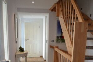 Eine Treppe mit Holzgeländern führt zu einer Tür.
