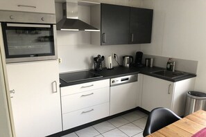A compact kitchen with a built-in oven, a coffee maker, and a trash bin. - Holiday home in Makkum with swimming pool (Makkum)