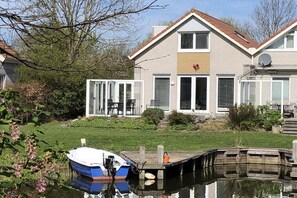 A two-story house with a dock and a boat. - Holiday home in Makkum with swimming pool (Makkum)