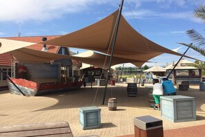 A covered outdoor area with a boat, barrels, and wooden structures. - Cabin in Renesse with swimming pool (Renesse)