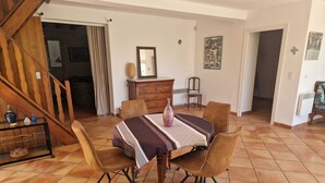Un comedor con una mesa, sillas y una escalera.