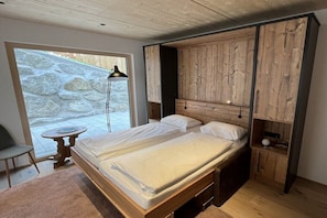 A bedroom with a bed, a small table, and a chair. - Severin Quarter || Berwang (Berwang)