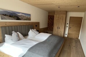 A bedroom with a bed, a wooden headboard, a wardrobe, and a door.