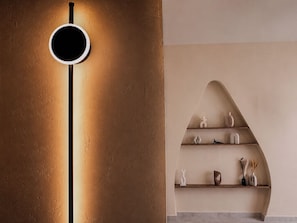 Ein modernes Interieur mit einer wandmontierten Leuchte und einer gebogenen Regaleinrichtung.