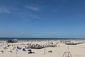 Ein Strand mit vielen Zelten und einem Steg.