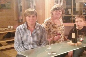 Ein Esstisch mit einer Weinflasche, Gläsern und einem Untersetzer aus Holz.