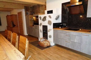 A modern kitchen with wooden cabinets, a stone accent wall, and a built-in oven.