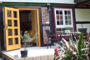 Ein Gebäude mit gelber Tür, einer Ziegelwand, einem weißen Fenster und einem Blumentopf.