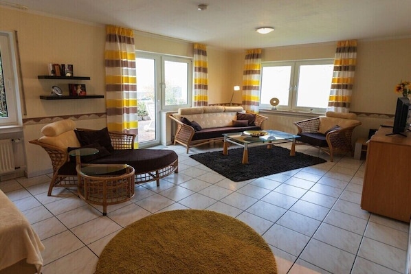 A living room with a sofa, chairs, a coffee table, and a TV. - Sunflower, terrace and Moselle view (Cochem)