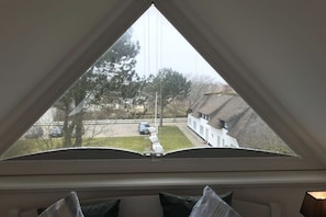 A room with a triangular window overlooking a residential area. - Holiday apartment with 2 bedrooms (Westerland)