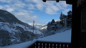 Eine verschneite Berglandschaft mit einem hölzernen Balkon.