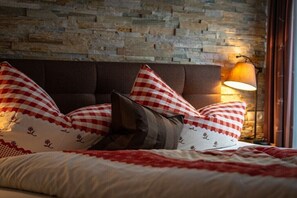 Ein Bett mit karierten Kissen, eine Steinsäule und eine Lampe.