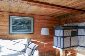 Ein Holzblockhaus-Interieur mit einem gerahmten Gemälde, einer Stehlampen und einem Kamin aus Stein.