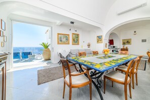 A dining area with a large table, chairs, and a view of the sea. - Estate4home - Villa Lettieri (Praiano)