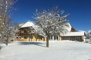 A two-story building with a snow-covered roof and a balcony. - Chalet Tubbs (4 persons) (Mauterndorf)