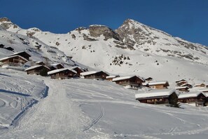 A snow-covered mountain with wooden chalets.